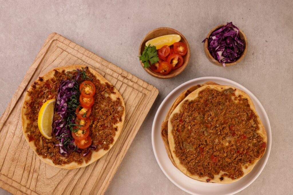 Lahmacun Döner Zubereitung mit frischem Döner-Fleisch, Eisbergsalat, Rotkohl und Sauces vor dem Rollen, Schritt-für-Schritt Anleitung