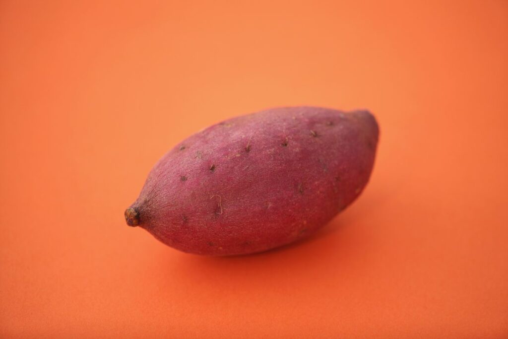 Süßkartoffeln in gleichmäßige Spalten schneiden auf Schneidebrett