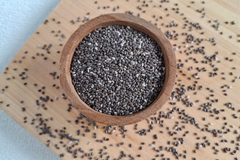 Chia Samen mit Milch in Glas für Chia Pudding vorbereiten